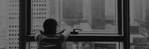 Person looking out window at cityscape, exploring future revenue strategies.