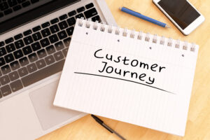 Customer journey diagram on notebook with laptop and pen