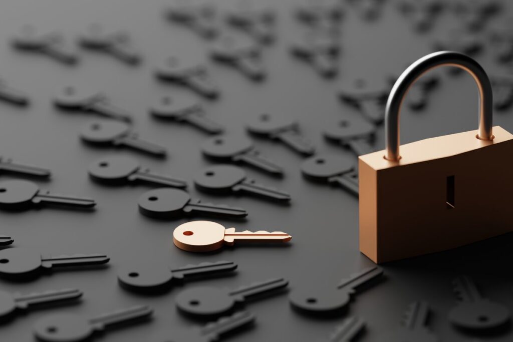 One copper key among many dark keys, beside a copper padlock